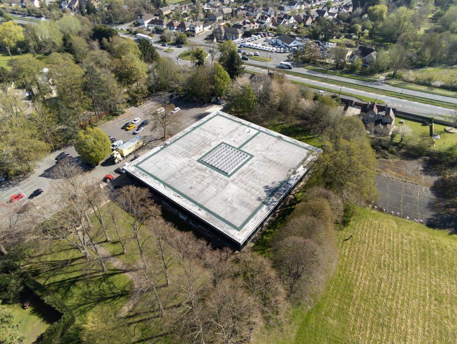 Aerial view of a building showcasing its roof and surrounding area, highlighting architectural features and layout.