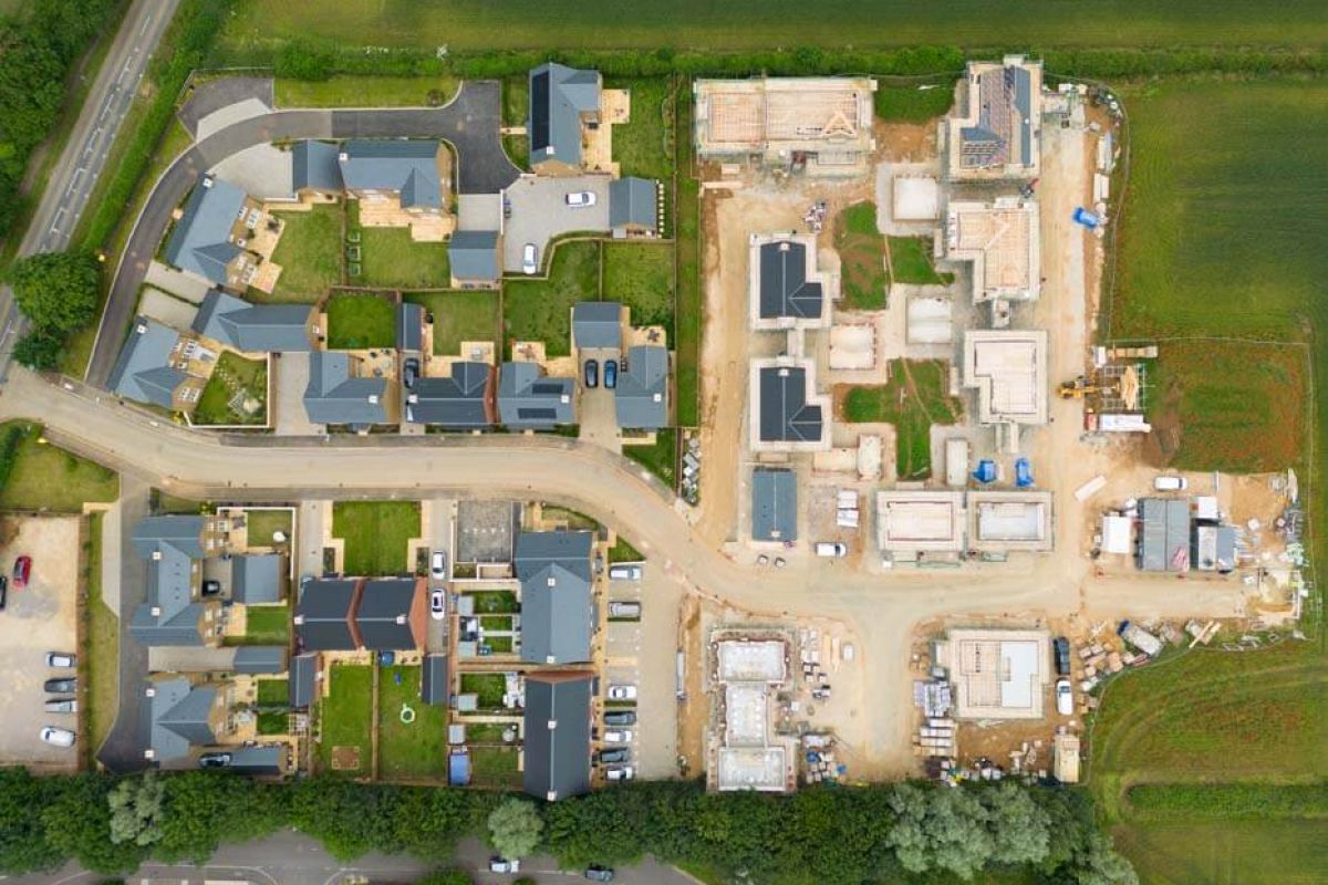 Aerial view showcasing a modern residential development with neatly arranged homes and green spaces.
